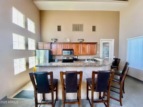 a kitchen with stainless steel appliances granite countertop a white table and chairs