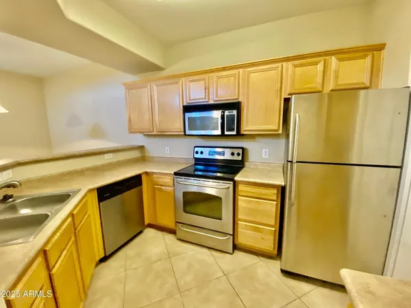 a kitchen with stainless steel appliances granite countertop a refrigerator sink stove and microwave
