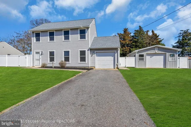 a front view of a house with a garden and yard