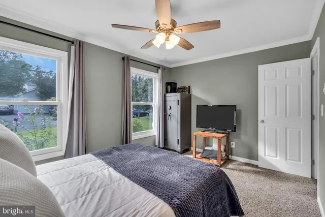 a bedroom with a bed and a flat tv screen on dresser