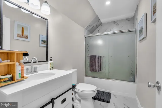 a bathroom with a sink toilet vanity and shower