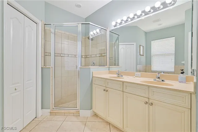 a bathroom with a double vanity sink mirror and shower