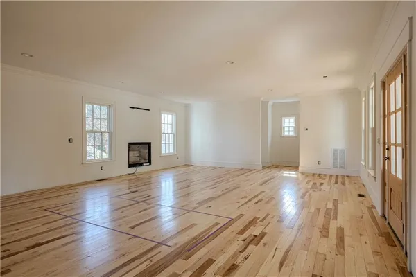 a view of empty room with wooden floor and fireplace