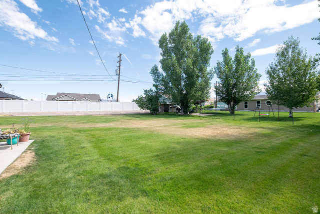 855 East 300 N Street Beaver, UT 84713 - Photo 13 of 44 Expansive green lawn with mature trees and a white privacy fence