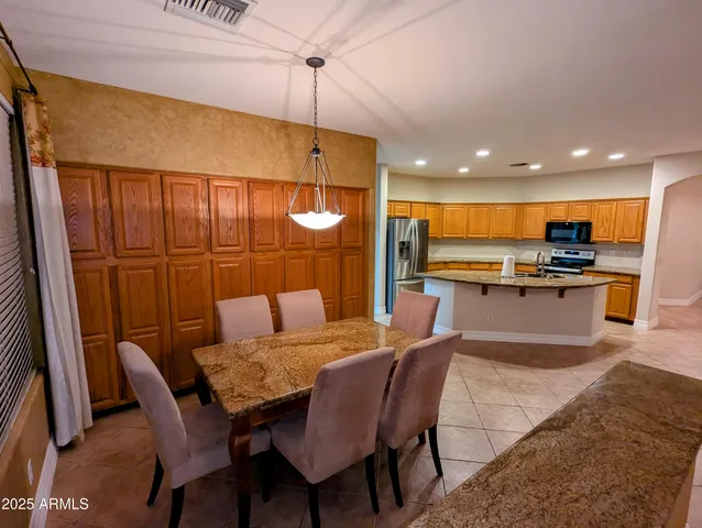 a kitchen with a table chairs refrigerator and microwave