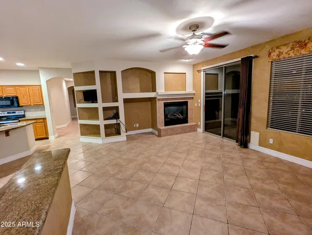 a view of an empty room with a fireplace and a window
