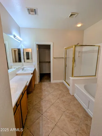 a bathroom with a granite countertop sink a mirror and shower