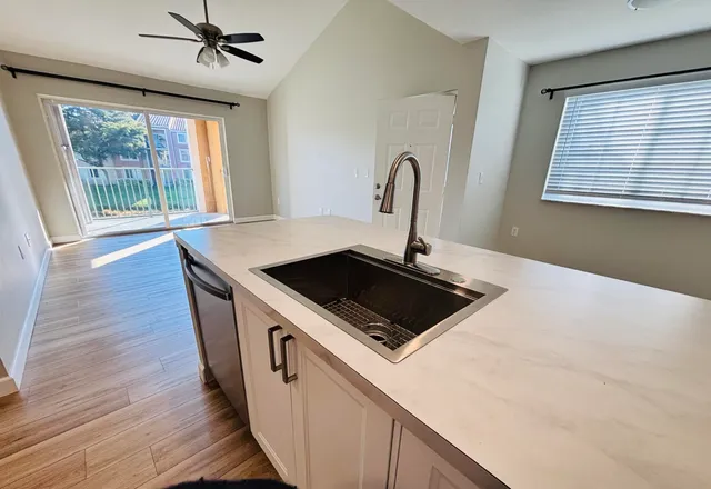 a kitchen that has a stove a sink and a large window