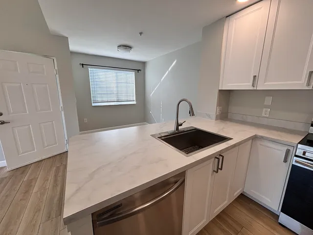 a kitchen with a sink cabinets and wooden floor