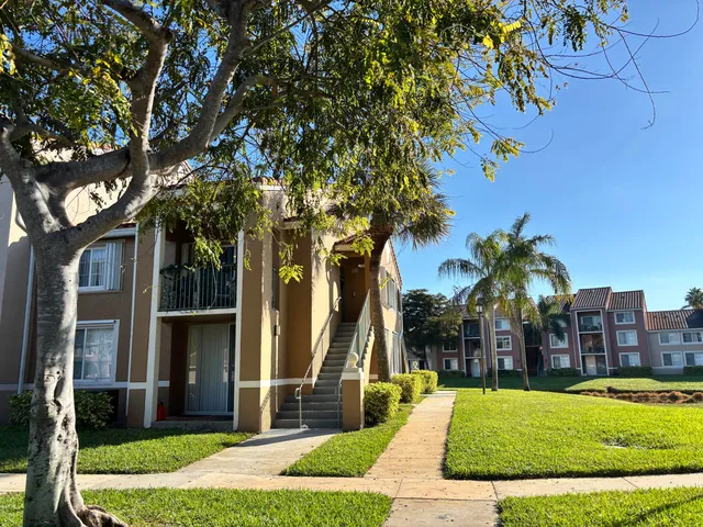 a view of a park with a tree in front of a house