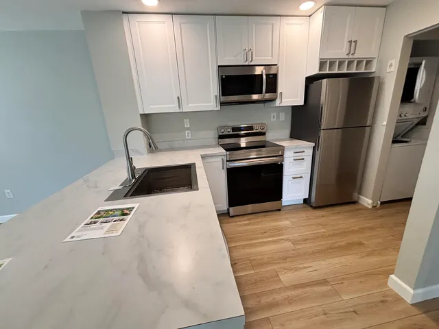 a kitchen with granite countertop a refrigerator stove and microwave
