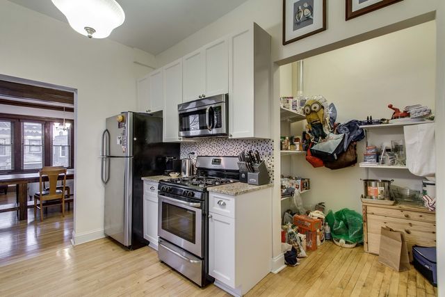 a kitchen with a refrigerator and a stove top oven