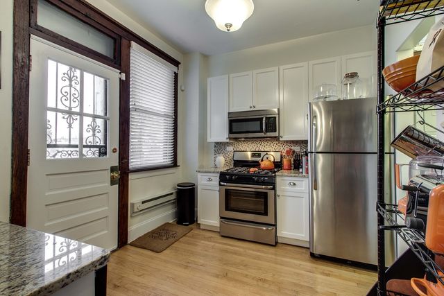 a kitchen with stainless steel appliances granite countertop a refrigerator a stove a sink and a microwave