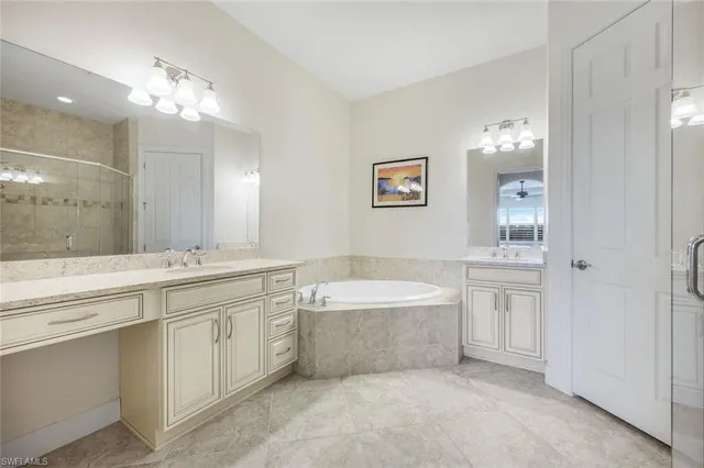 a spacious bathroom with a tub a sink and mirror