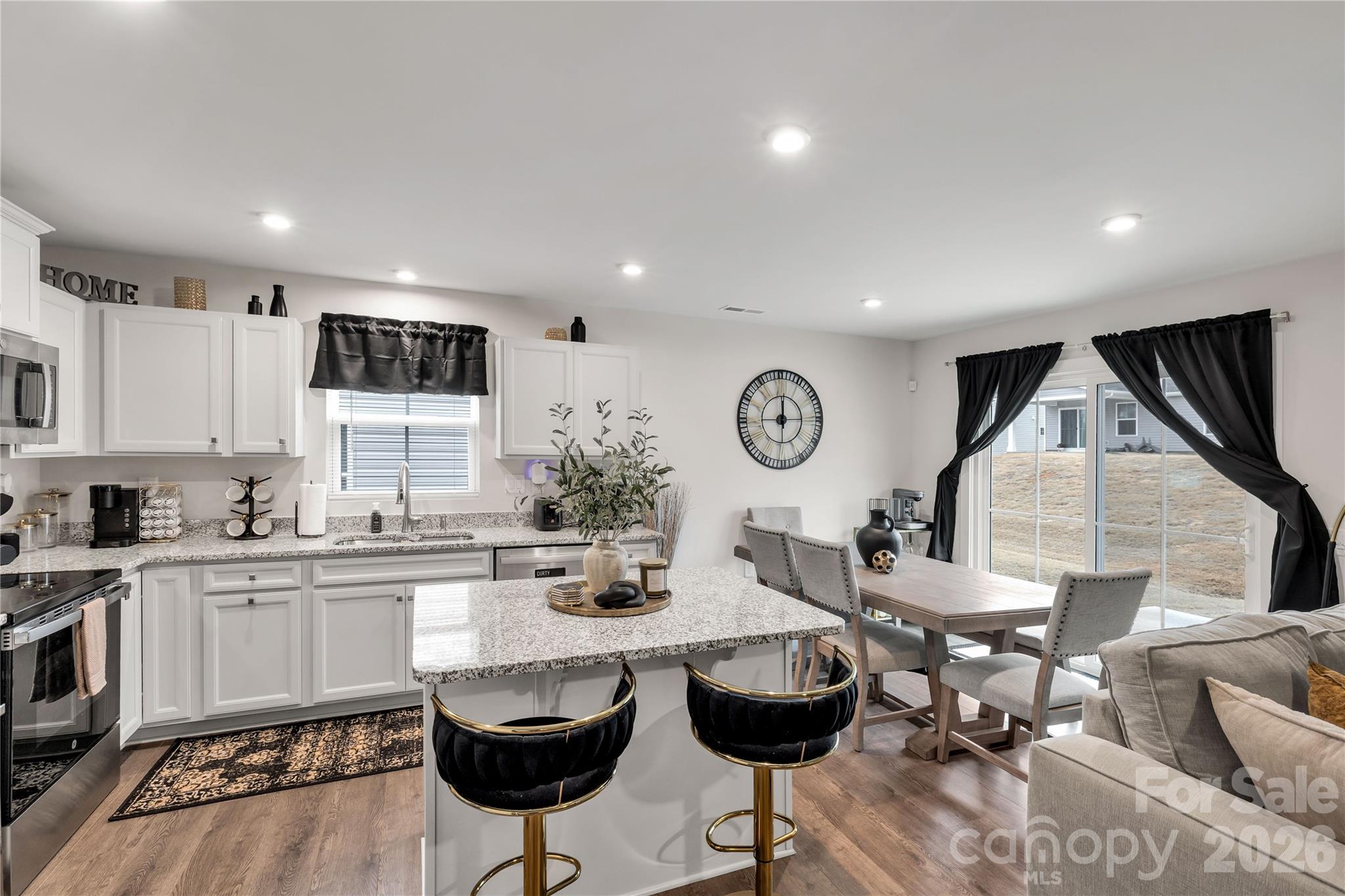 810 Purslane Street Lancaster, SC 29720 - Photo 7 of 24 a kitchen with granite countertop a stove a sink a dining table and chairs