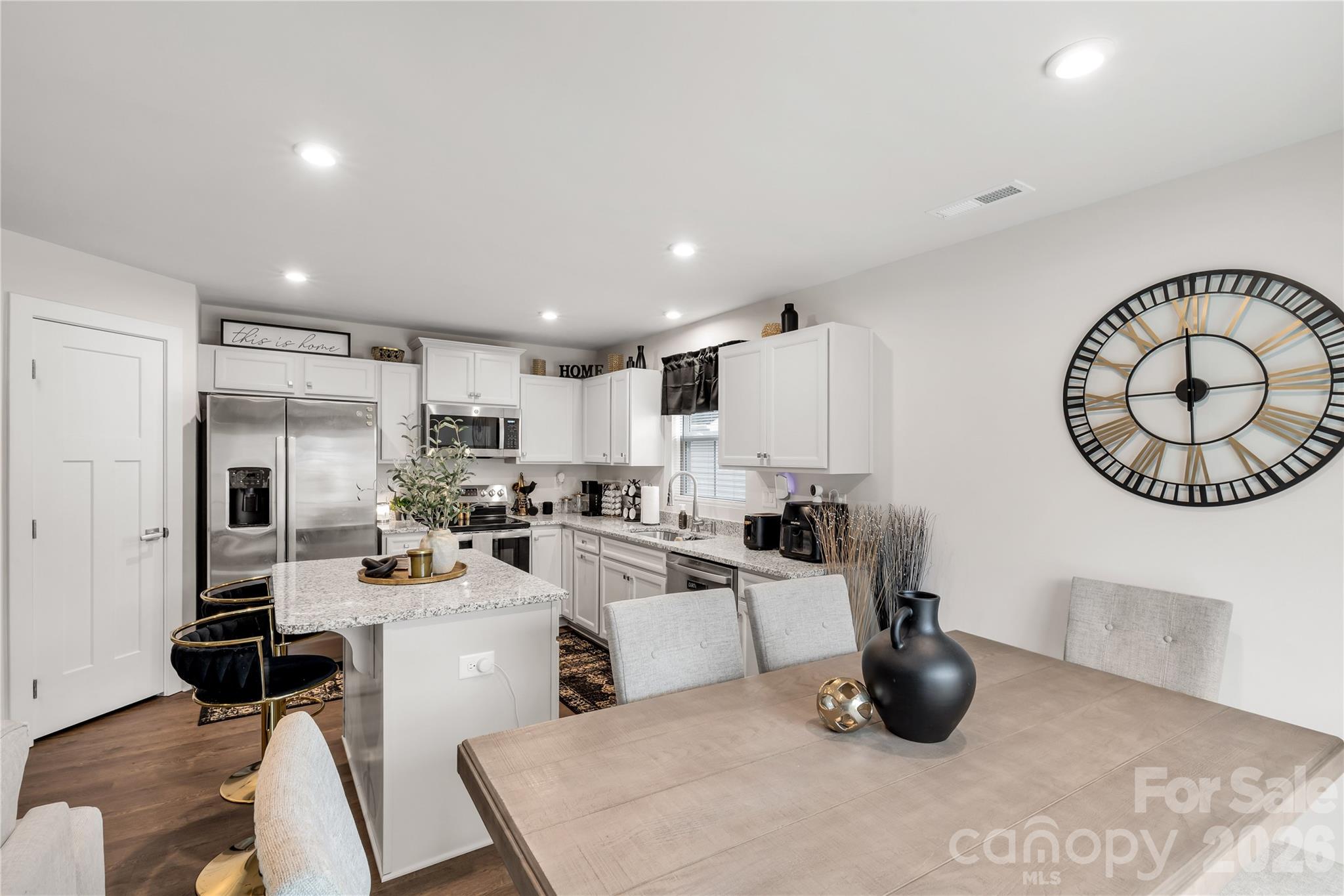 810 Purslane Street Lancaster, SC 29720 - Photo 8 of 24 a kitchen with a sink a stove and chairs with wooden floor
