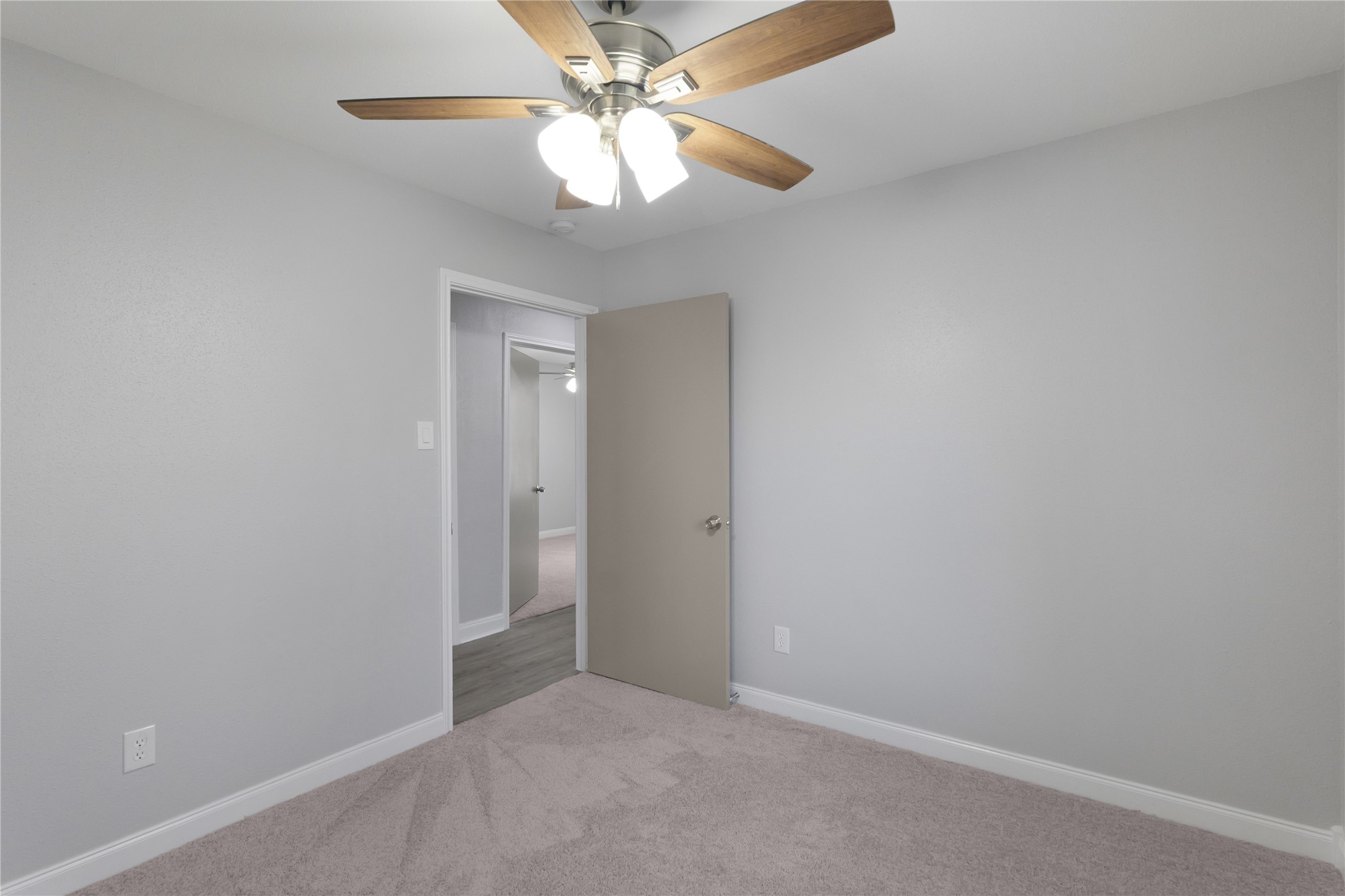 9827 Shive Drive Houston, TX 77078 - Photo 11 of 15 an empty room with a chandelier fan and a ceiling fan