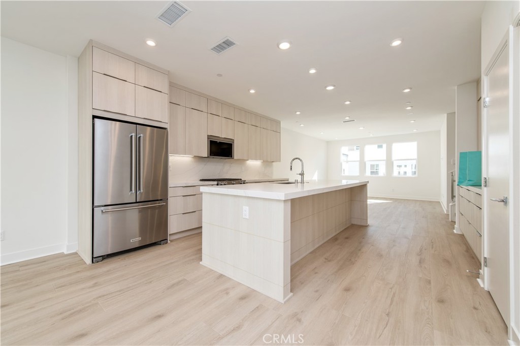 2604 Everly Drive San Diego, CA 92108 - Photo 11 of 33 a large kitchen with a center island wooden floor stainless steel appliances and windows