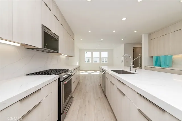 a kitchen with white cabinets and appliances