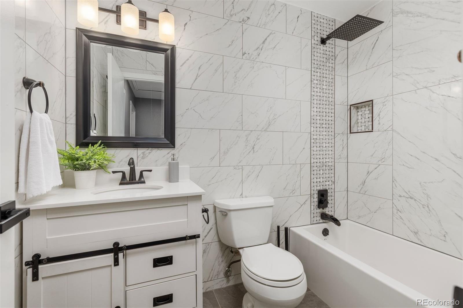 3692 South Mobile Way Aurora, CO 80013 - Photo 23 of 48 a bathroom with a sink a toilet a mirror and shower