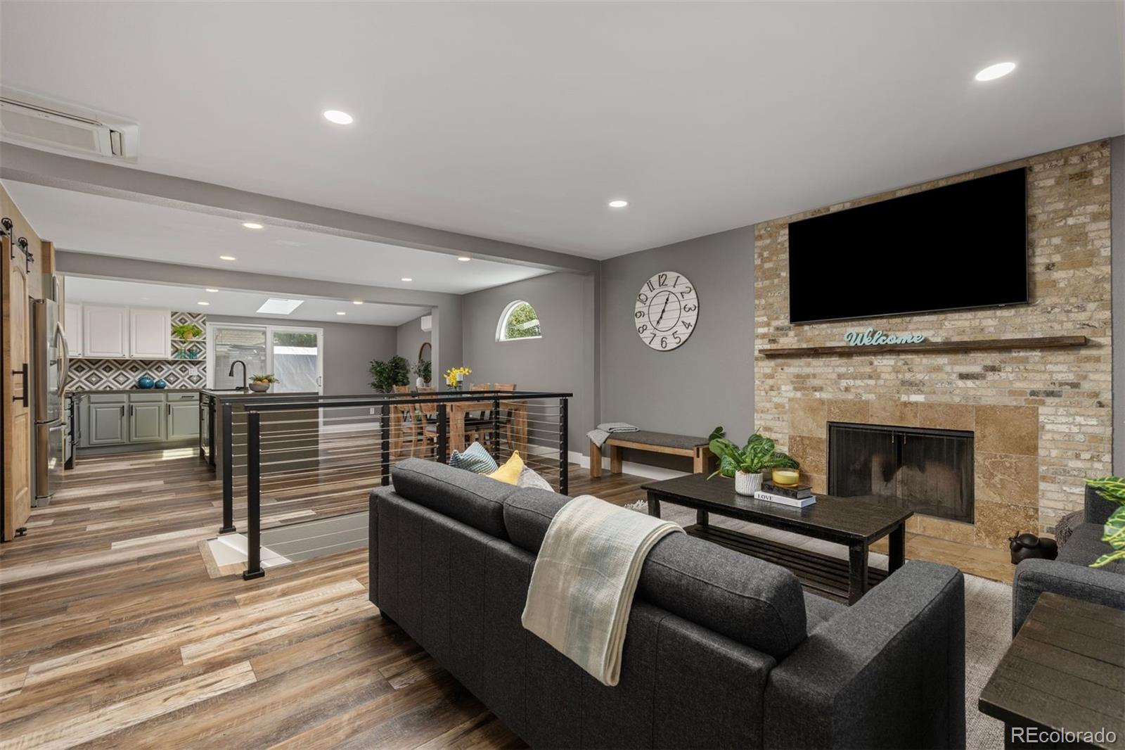 3692 South Mobile Way Aurora, CO 80013 - Photo 5 of 48 a living room with furniture a flat screen tv and a fireplace