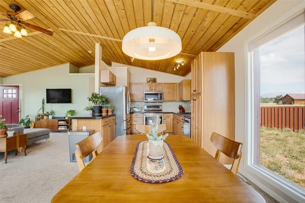 a kitchen with stainless steel appliances granite countertop a refrigerator a sink dishwasher a stove and white cabinets with wooden floor