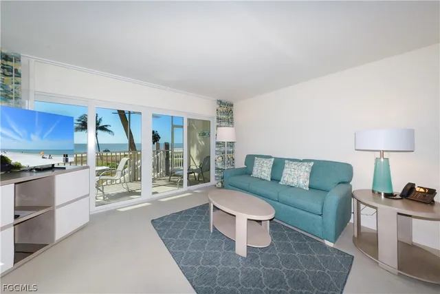 a living room with furniture a large window and a coffee table