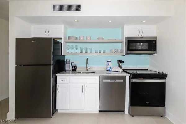 a kitchen with stainless steel appliances a refrigerator stove and microwave