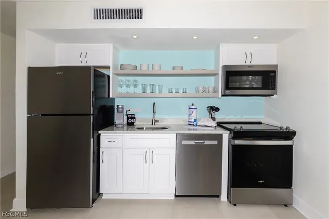 a kitchen with stainless steel appliances a refrigerator stove and microwave