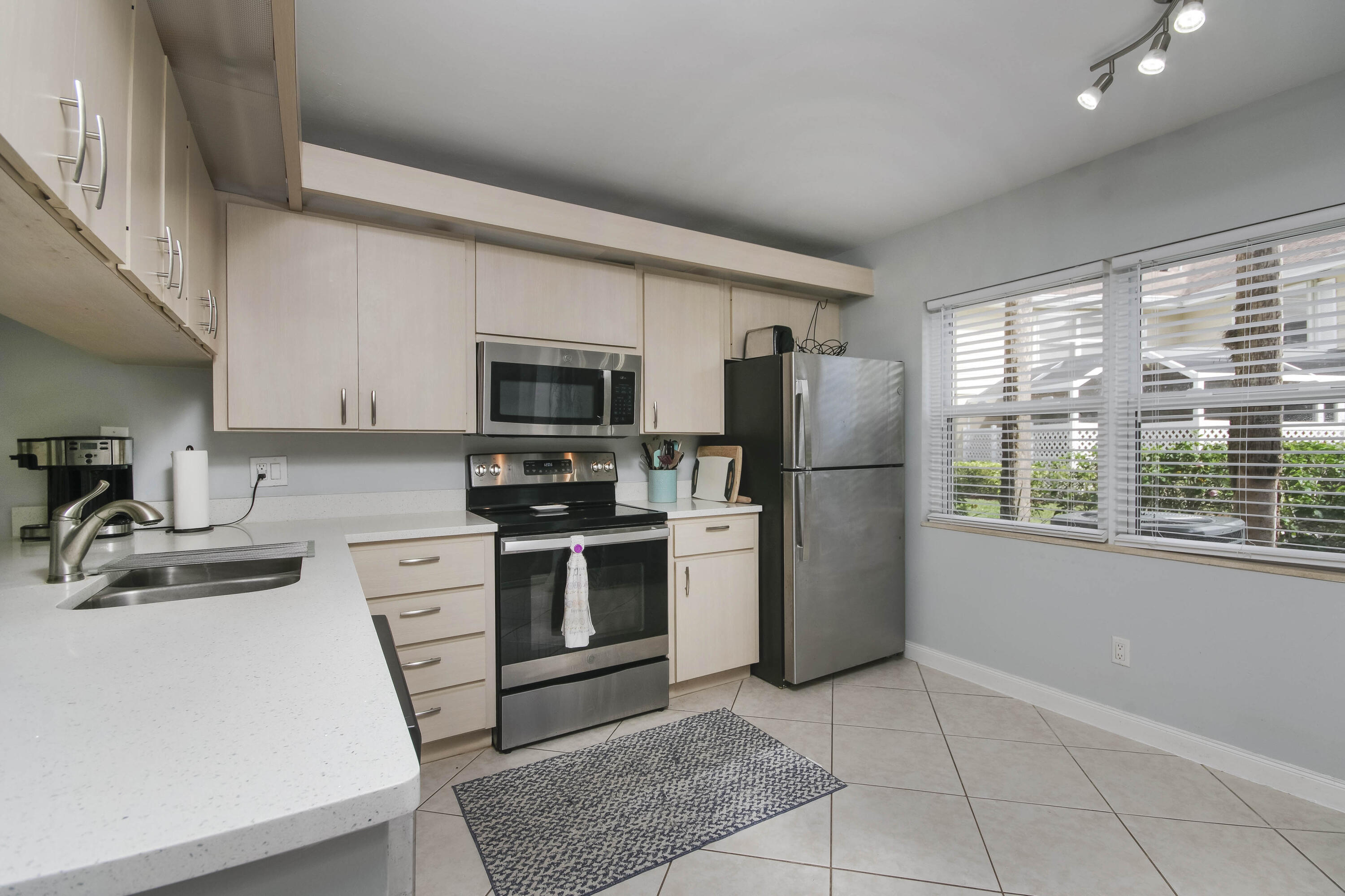 4603 Roxbury Court Boynton Beach, FL 33436 - Photo 9 of 19 a kitchen with a refrigerator a stove top oven a sink dishwasher and wooden cabinets