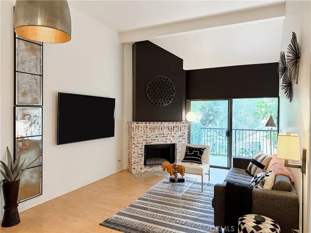 a living room with furniture a flat screen tv and a fireplace