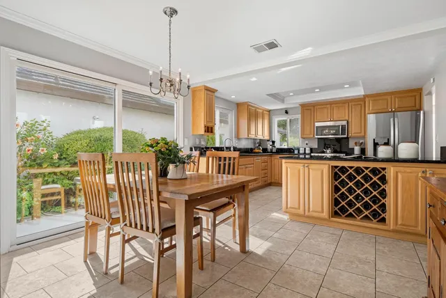 a kitchen with granite countertop a table chairs microwave and cabinets