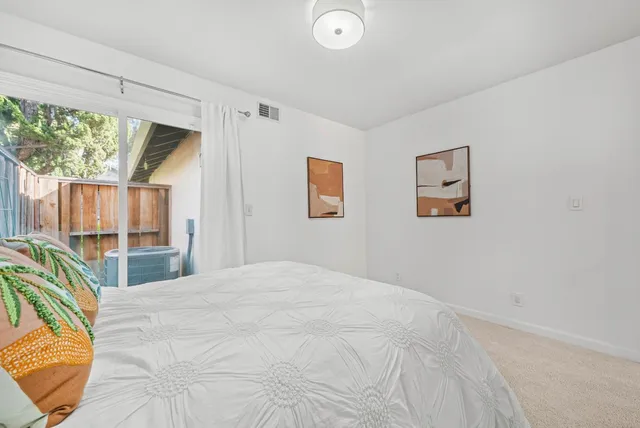 a bedroom with a bed and a large window