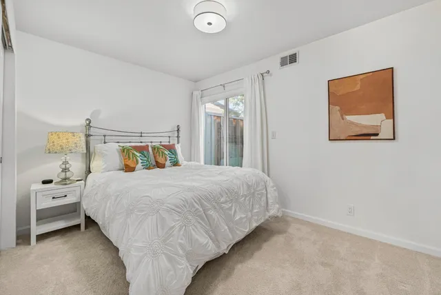 a bedroom with a bed and a painting on the wall