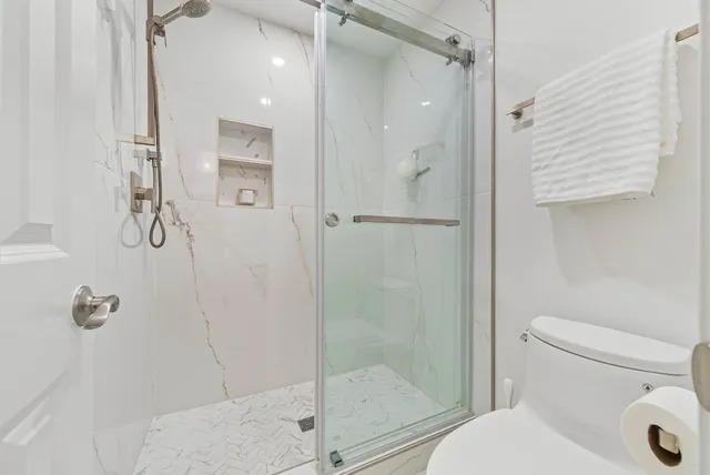 a bathroom with a shower a toilet and a sink