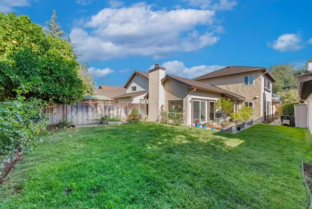 a view of a house with backyard sitting area and garden