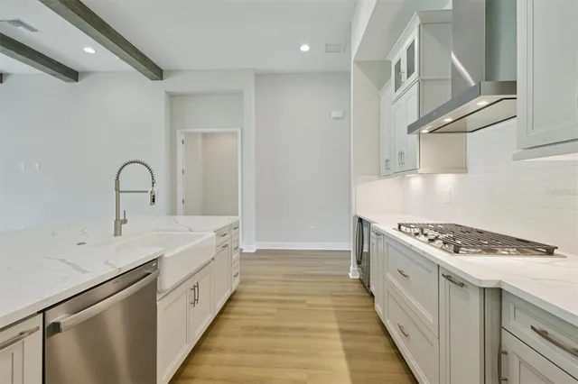 a kitchen with granite countertop a sink stove and cabinets