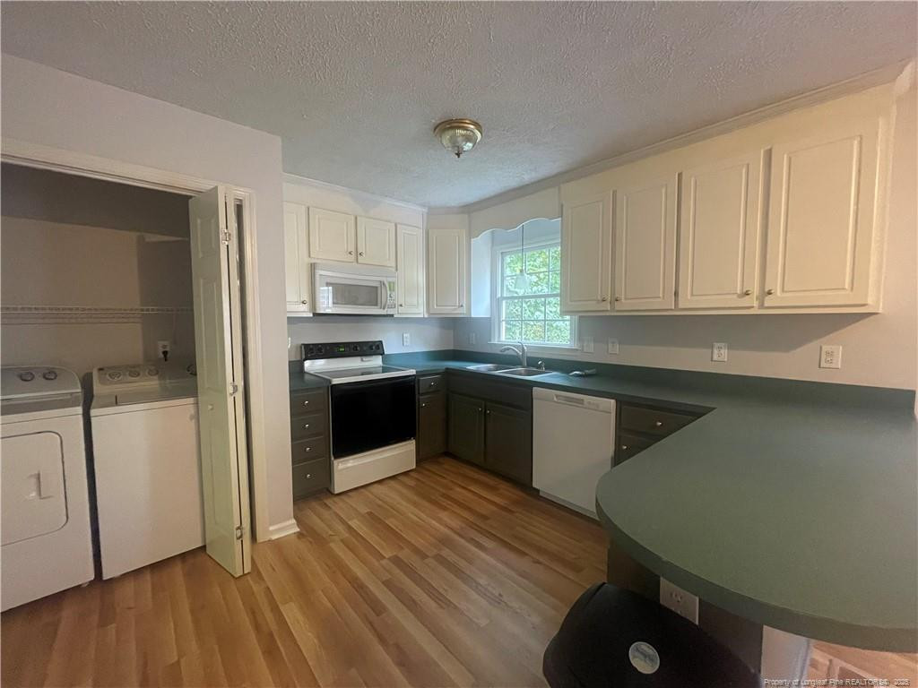 4219 Arbutus Drive, Unit A Raleigh, NC 27612 - Photo 11 of 30 a kitchen with granite countertop a sink cabinets and stainless steel appliances