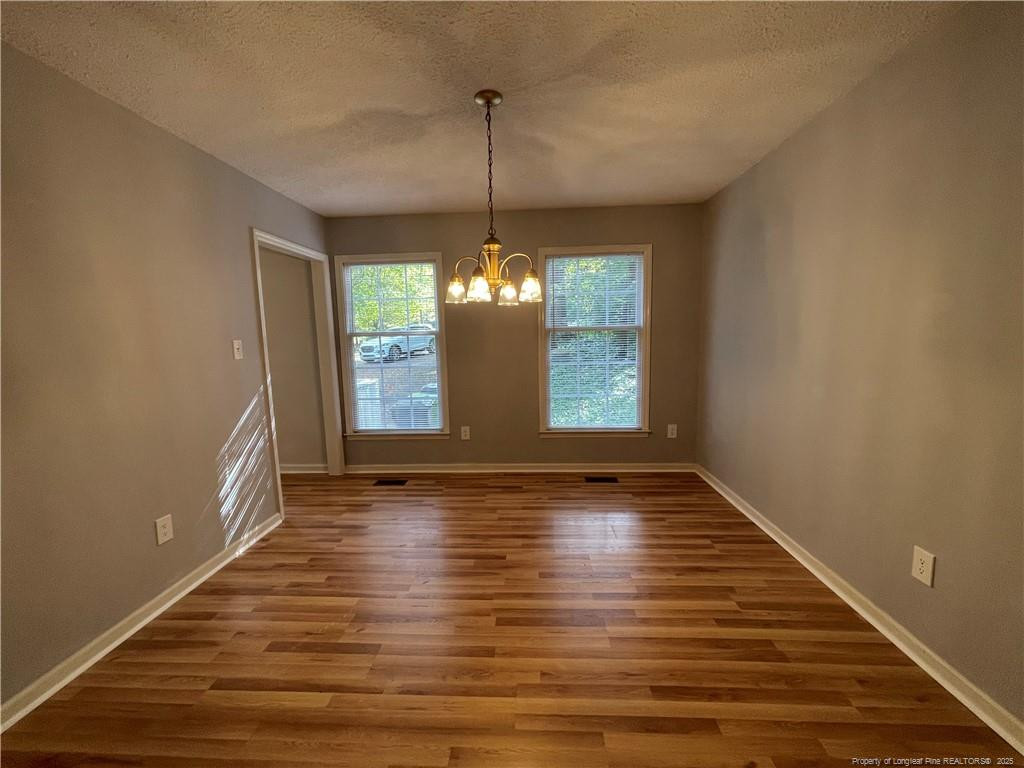 4219 Arbutus Drive, Unit A Raleigh, NC 27612 - Photo 12 of 30 a view of an empty room with wooden floor and a window