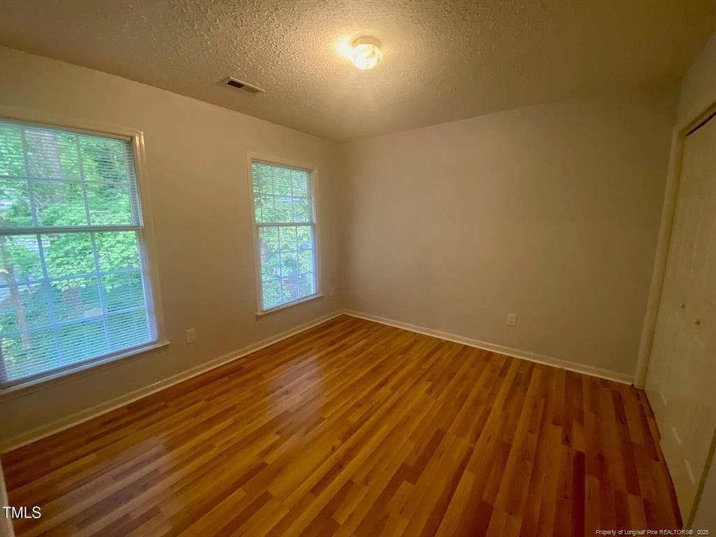 4219 Arbutus Drive, Unit A Raleigh, NC 27612 - Photo 18 of 30 a view of empty room with wooden floor and fan