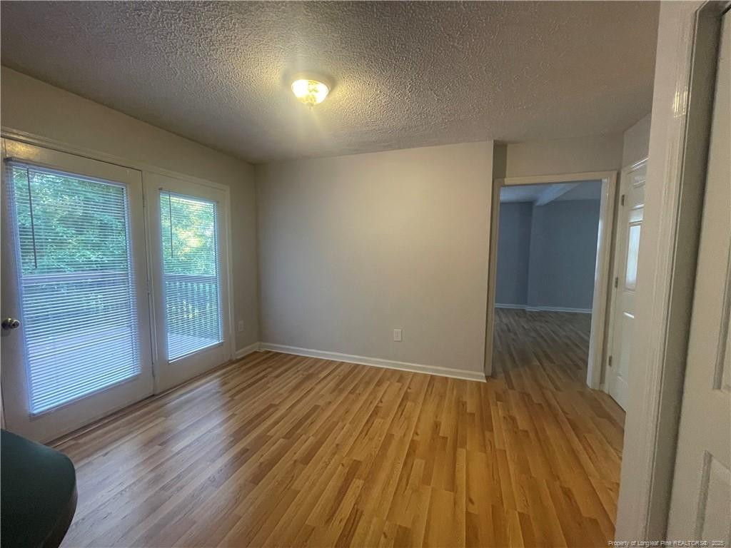 4219 Arbutus Drive, Unit A Raleigh, NC 27612 - Photo 19 of 30 wooden floor in an empty room with a window