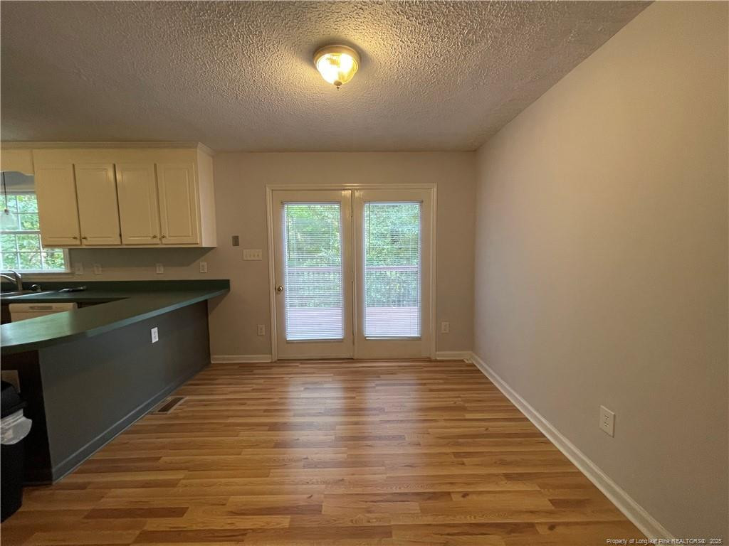 4219 Arbutus Drive, Unit A Raleigh, NC 27612 - Photo 30 of 30 a kitchen with kitchen island granite countertop a sink window and cabinets