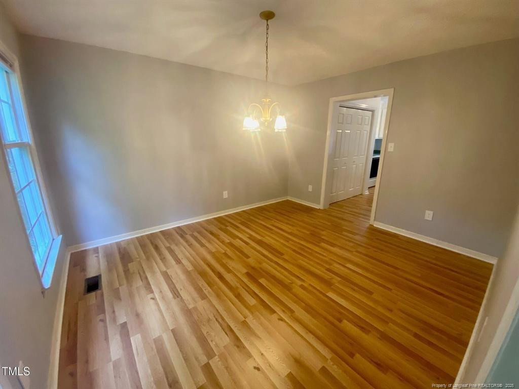 4219 Arbutus Drive, Unit A Raleigh, NC 27612 - Photo 5 of 30 a view of a room with wooden floor and white walls
