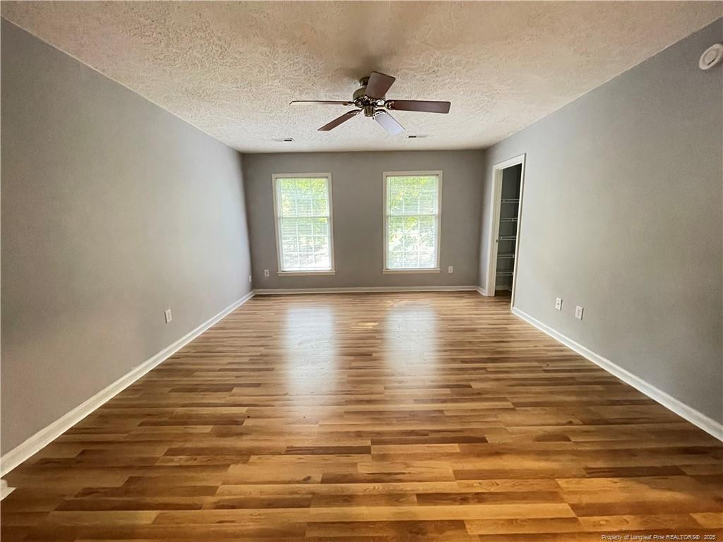 4219 Arbutus Drive, Unit A Raleigh, NC 27612 - Photo 7 of 30 a view of empty room with wooden floor and fan