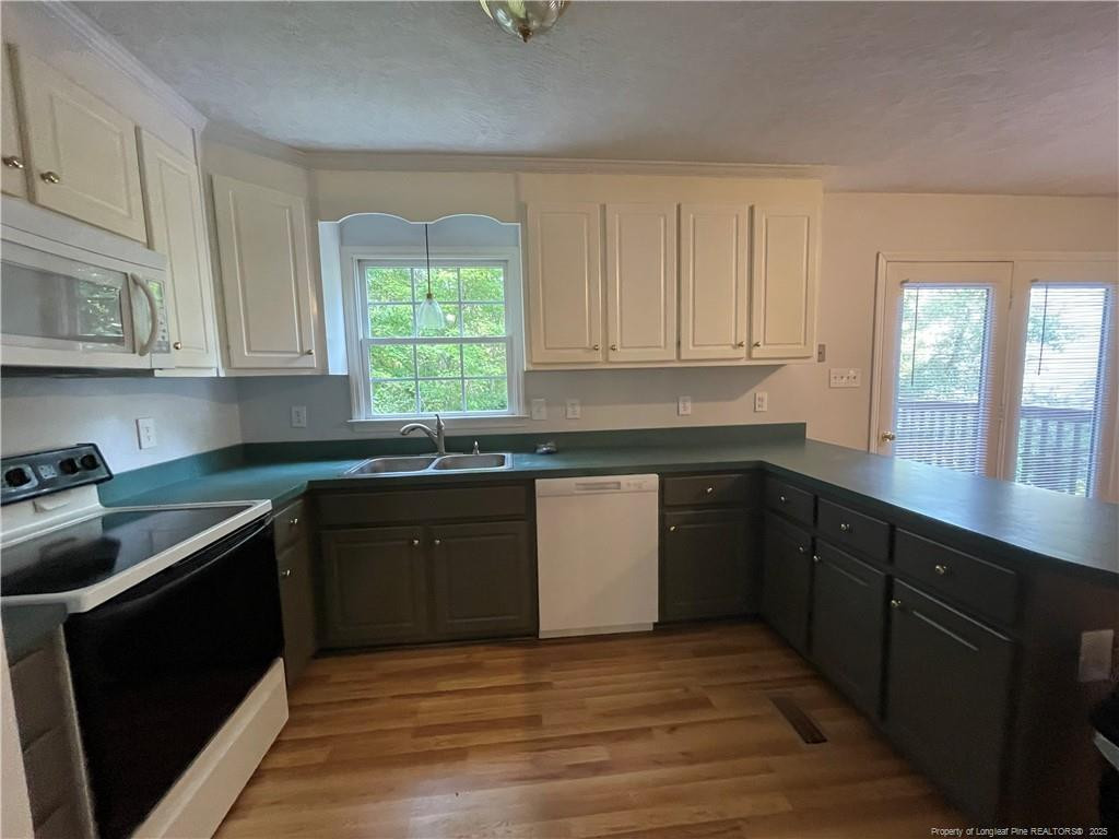 4219 Arbutus Drive, Unit A Raleigh, NC 27612 - Photo 8 of 30 a kitchen with granite countertop a sink window and cabinets