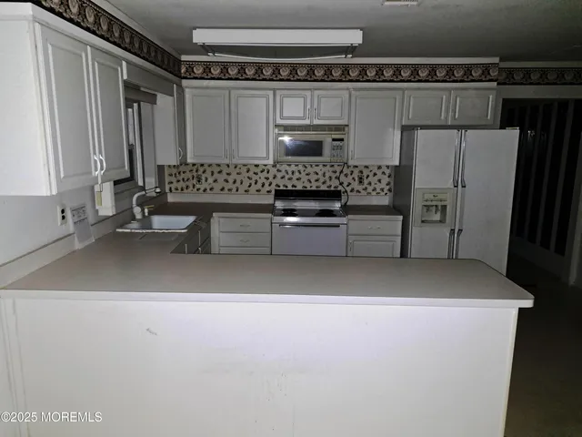 a kitchen with refrigerator and cabinets