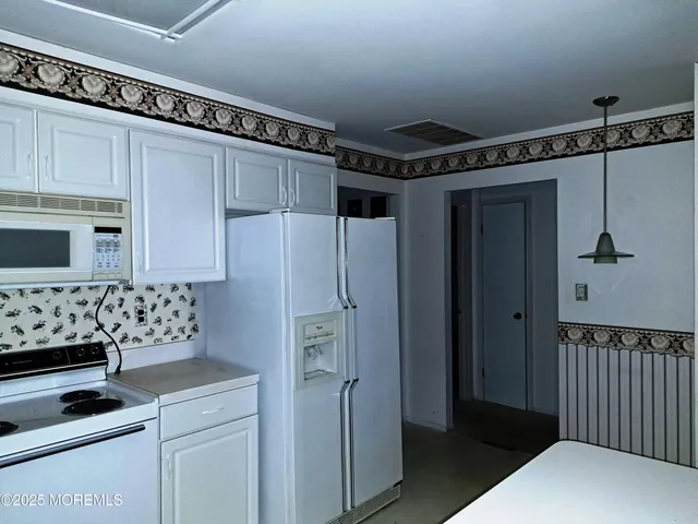 a kitchen with a refrigerator and a stove top oven