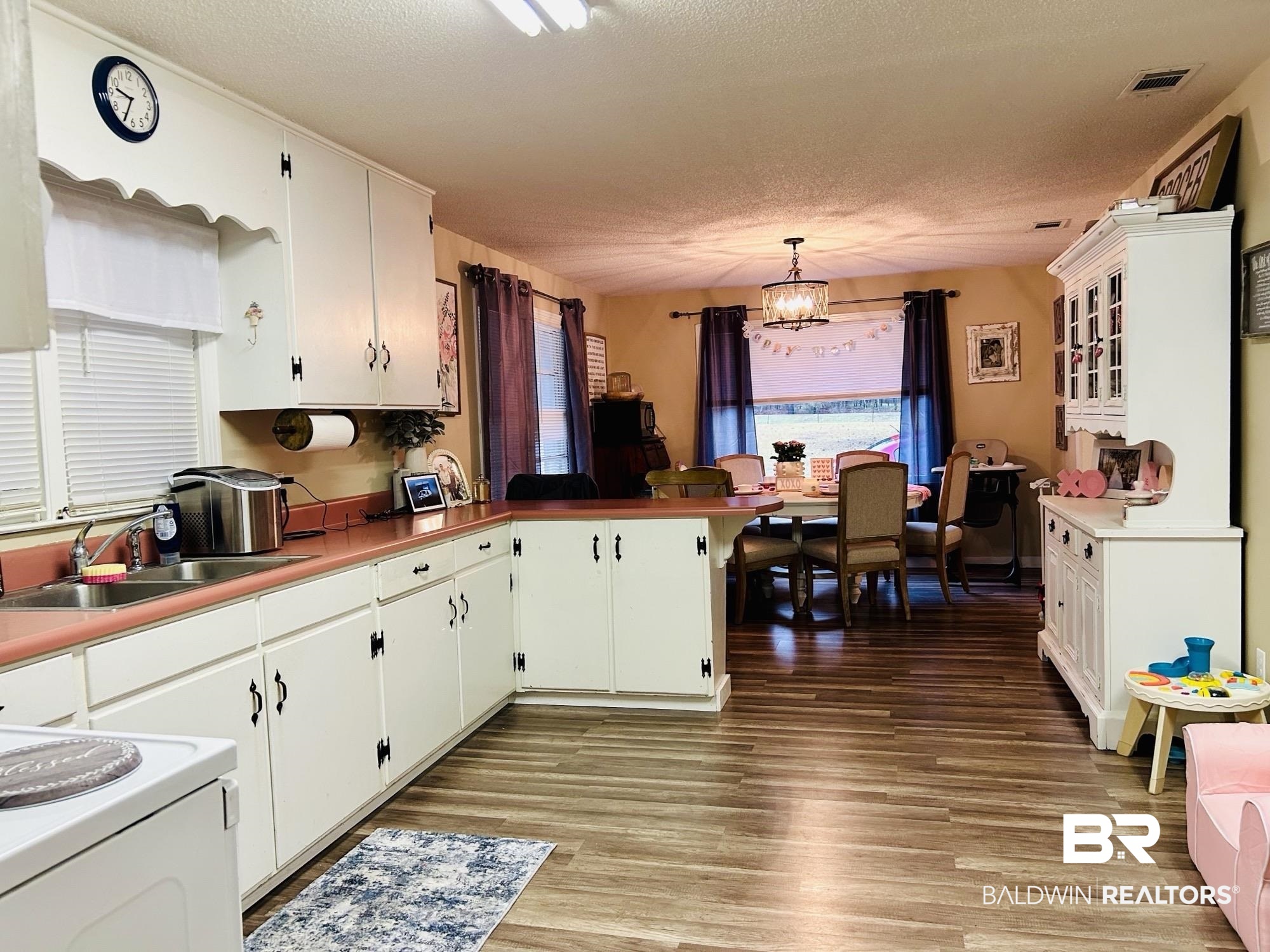 3850 Newman Road Mobile, AL 36695 - Photo 13 of 27 Kitchen with sink, white cabinets, decorative light fixtures, and a notable chandelier