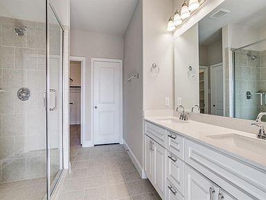 4717 Ladrillo Lane McKinney, TX 75070 - Photo 23 of 24 Bathroom with a spacious closet, a stall shower, double vanity, and light tile patterned flooring