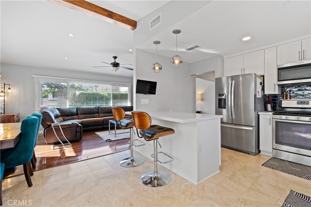 275 Mountain View Street Altadena, CA 91001 - Photo 10 of 30 a kitchen with stainless steel appliances kitchen island granite countertop a refrigerator a stove a dining table and chairs with a large window
